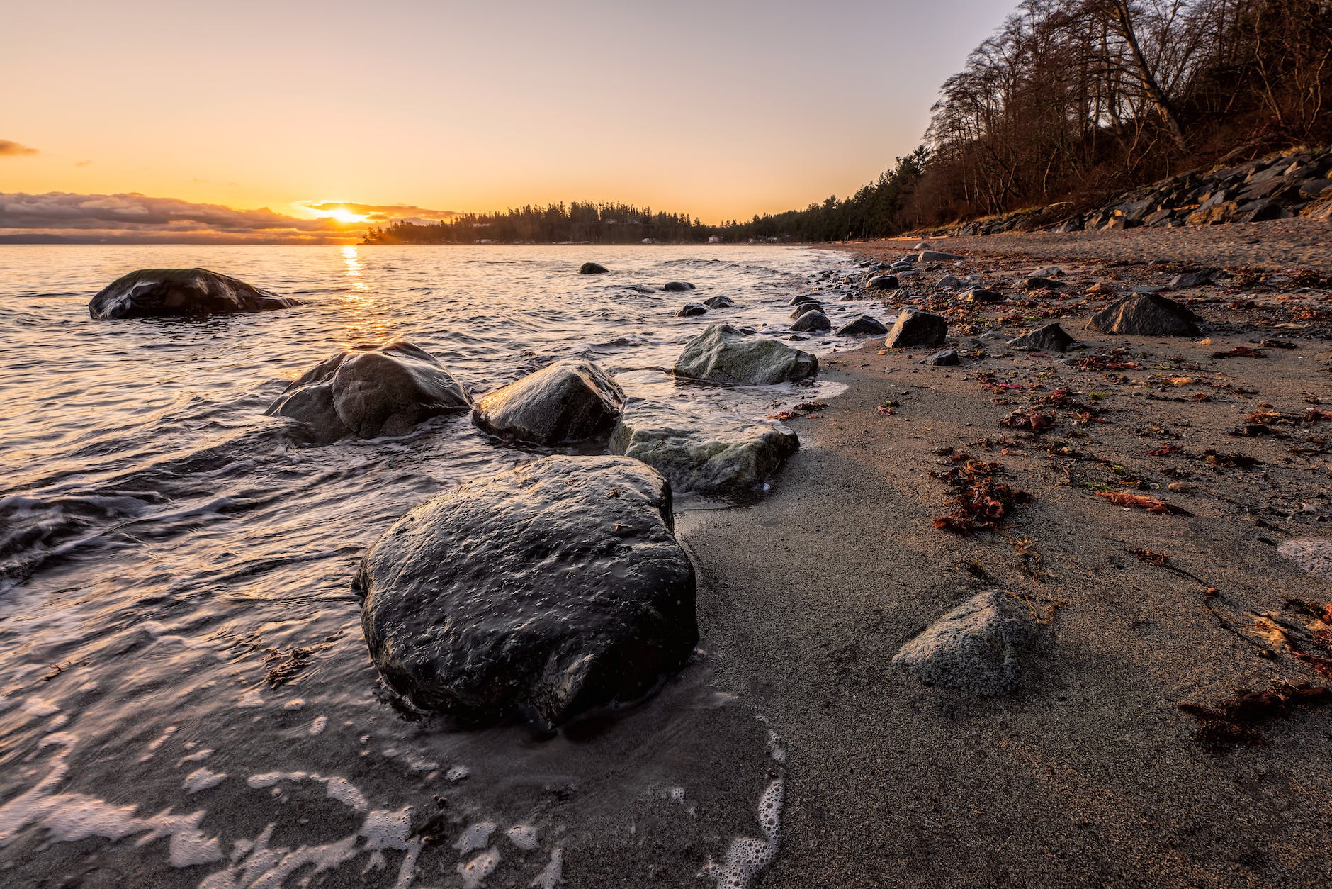 gray rocks on seashore during sunset